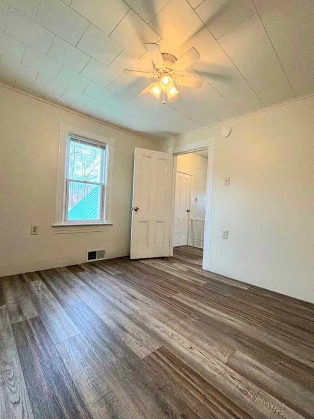 unfurnished room featuring ceiling fan and dark wood-type flooring