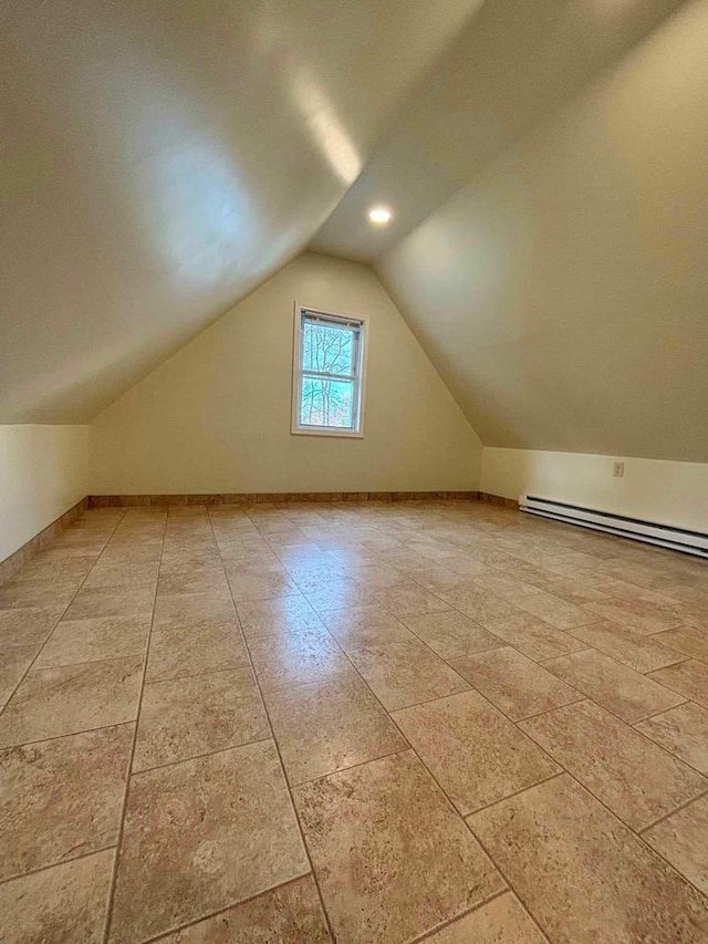 additional living space featuring baseboard heating and lofted ceiling