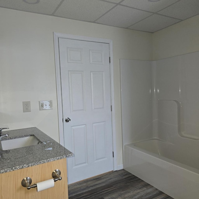 bathroom featuring vanity, hardwood / wood-style floors, a paneled ceiling, and tub / shower combination