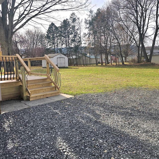 view of yard featuring a storage unit and a wooden deck