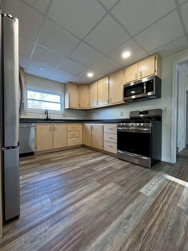 kitchen featuring dark hardwood / wood-style flooring, a drop ceiling, stainless steel appliances, and light brown cabinets