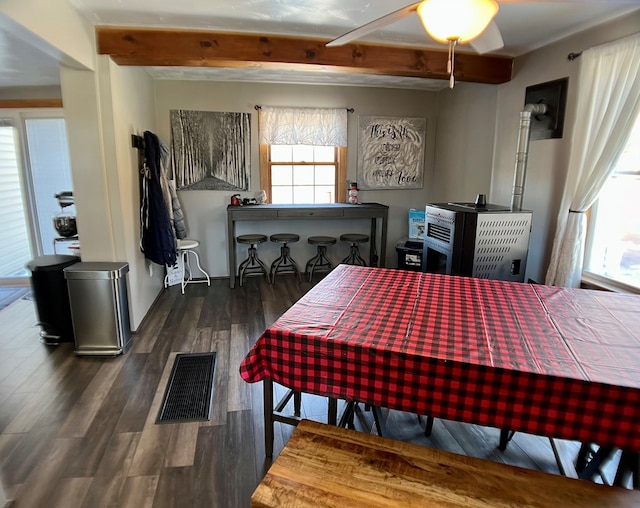 dining space featuring beam ceiling and dark hardwood / wood-style floors