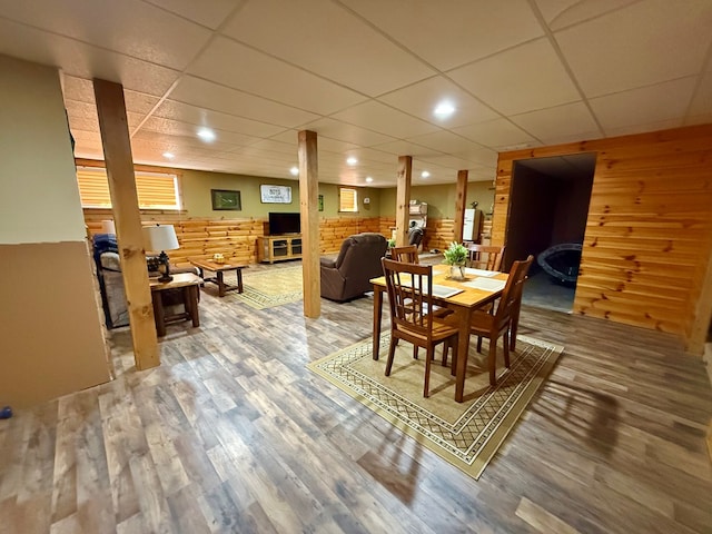 dining area with recessed lighting, wooden walls, a paneled ceiling, and light wood-style floors