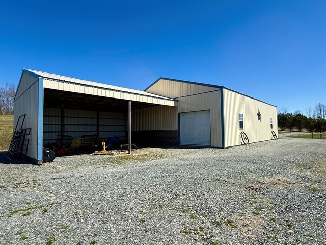 view of pole building with gravel driveway