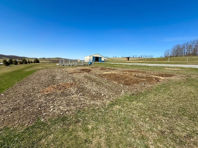 view of property's community with an outbuilding, a yard, and a rural view