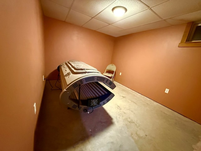miscellaneous room featuring concrete flooring and a paneled ceiling