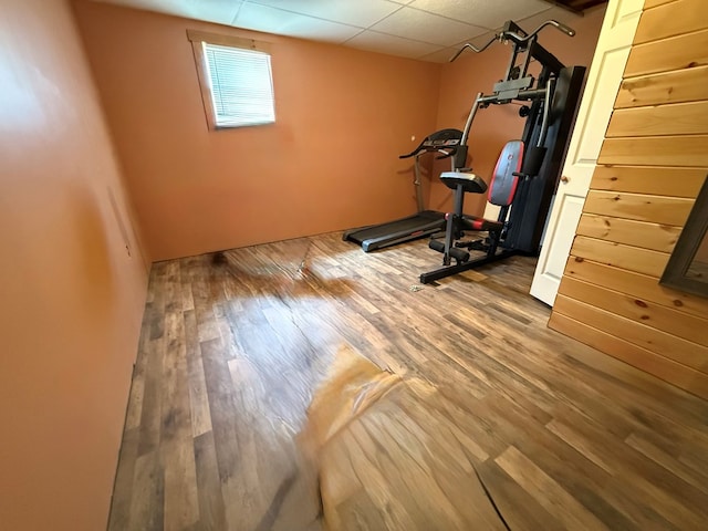 exercise room featuring wood finished floors and a paneled ceiling