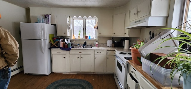 kitchen featuring white appliances, a sink, under cabinet range hood, dark wood-style floors, and white cabinetry