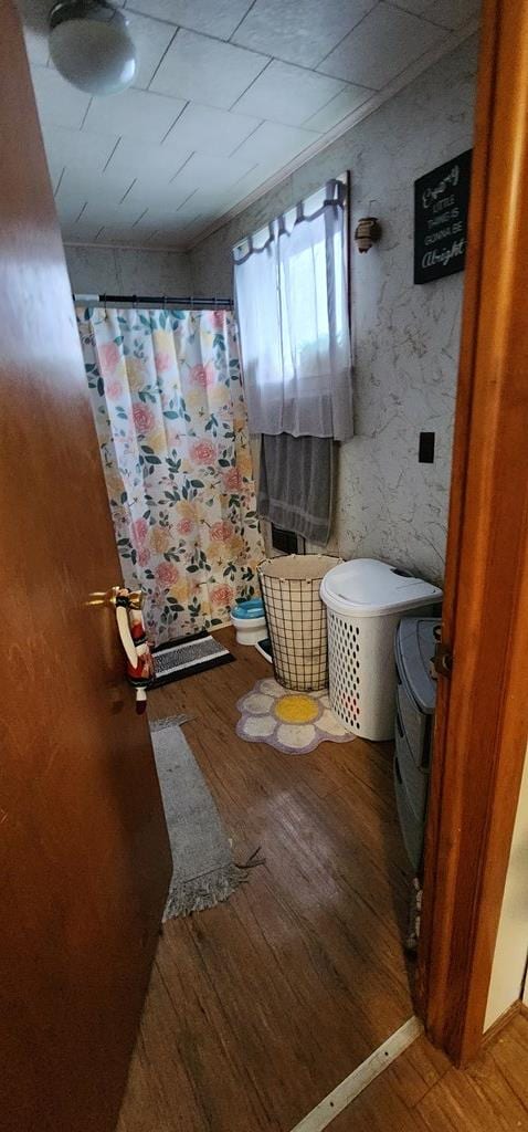 full bath featuring wood-type flooring and curtained shower