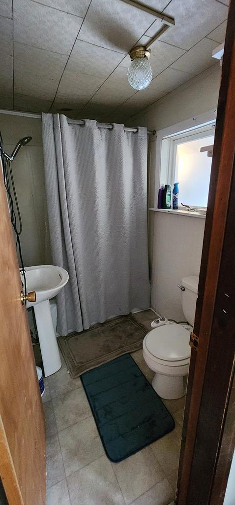 full bath featuring a shower stall and toilet