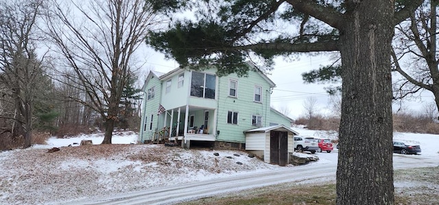 snow covered property featuring covered porch