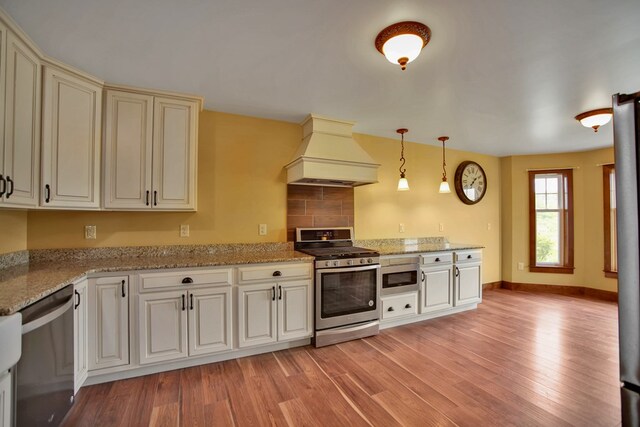 77 Hunters Trl, Wellsboro, PA 16901 - kitchen with appliances with stainless steel finishes, custom exhaust hood, light wood-style floors, and pendant lighting