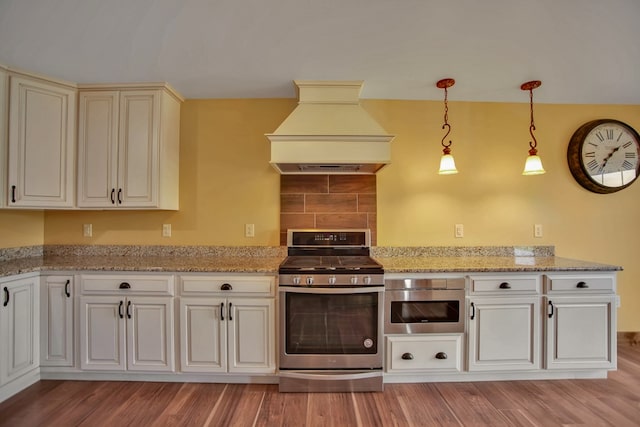 77 Hunters Trl, Wellsboro, PA 16901 - kitchen featuring stainless steel gas stove, premium range hood, light wood finished floors, hanging light fixtures, and light stone counters