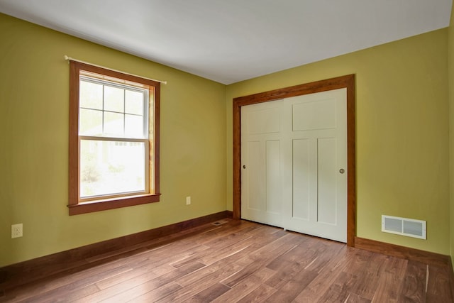 77 Hunters Trl, Wellsboro, PA 16901 - unfurnished bedroom featuring multiple windows, wood finished floors, baseboards, and a closet