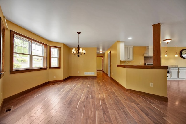 77 Hunters Trl, Wellsboro, PA 16901 - unfurnished living room featuring a chandelier, hardwood / wood-style flooring, baseboards, recessed lighting, and a sink