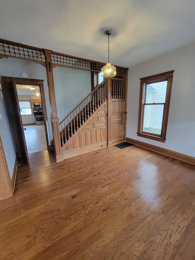 605 Wells Ave, Athens, PA 18810 - unfurnished dining area featuring wood finished floors, a chandelier, baseboards, and stairs