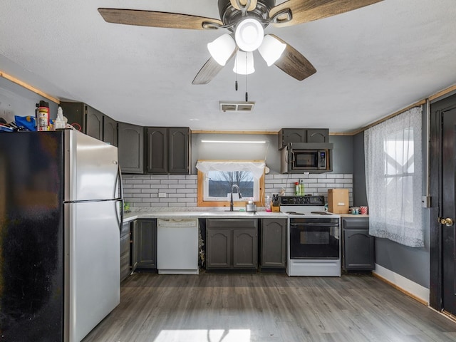 kitchen with appliances with stainless steel finishes, sink, dark hardwood / wood-style flooring, and plenty of natural light