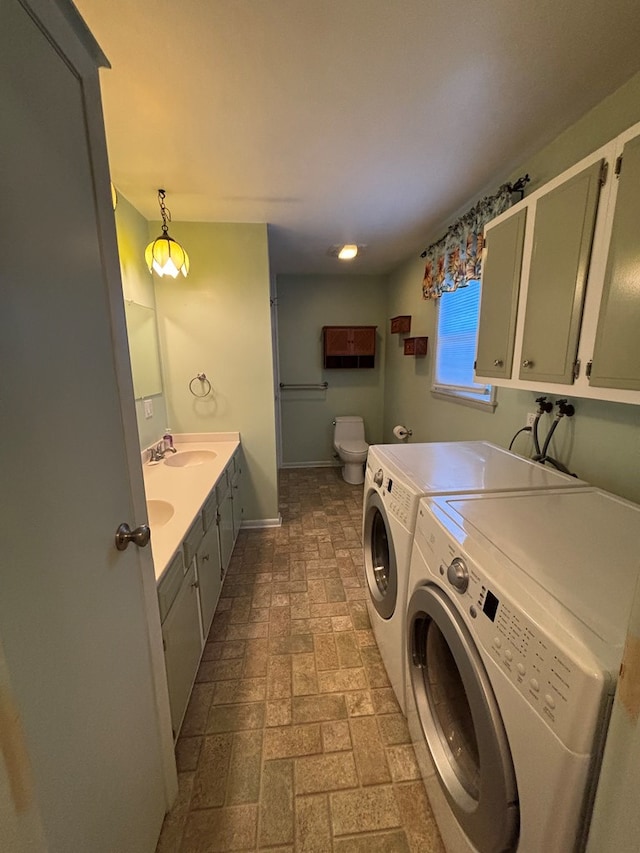 clothes washing area with independent washer and dryer and sink