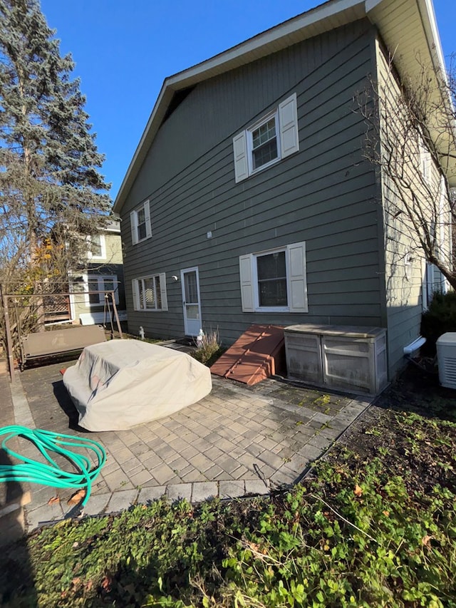 rear view of property with central AC and a patio area