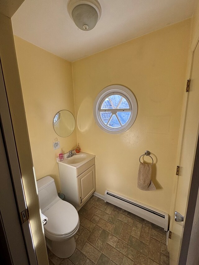 bathroom with vanity, toilet, and a baseboard radiator