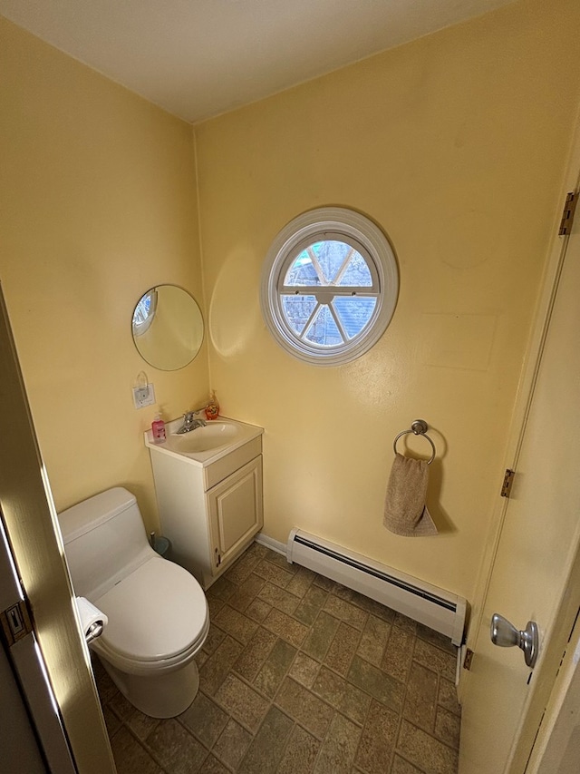 bathroom featuring baseboard heating, vanity, and toilet