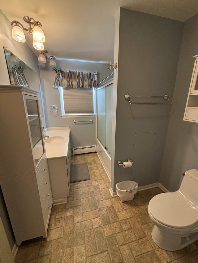 full bathroom featuring toilet, vanity, bath / shower combo with glass door, and a baseboard heating unit