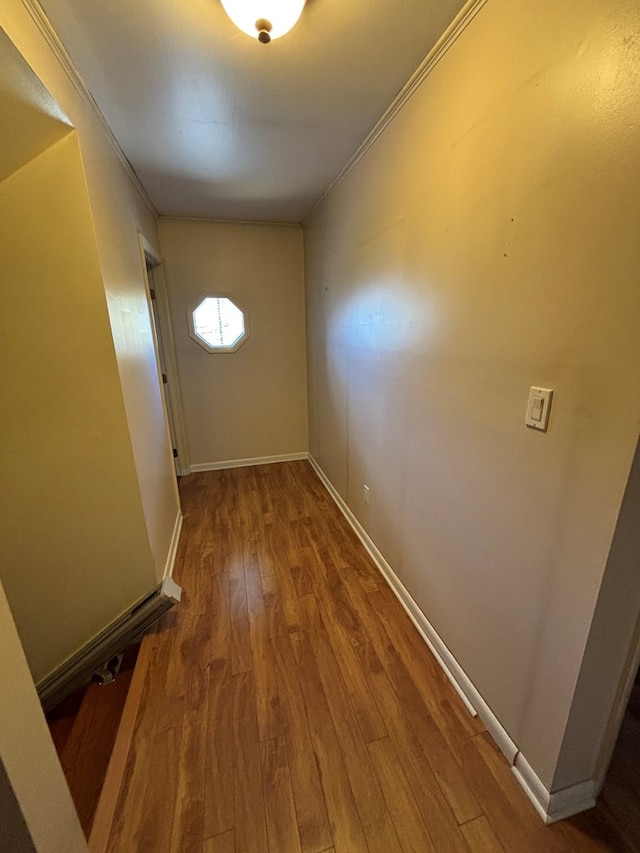 hallway with hardwood / wood-style floors and ornamental molding