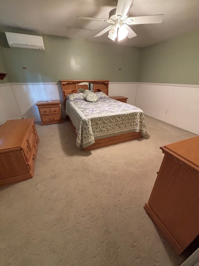 carpeted bedroom with a wall mounted AC and ceiling fan