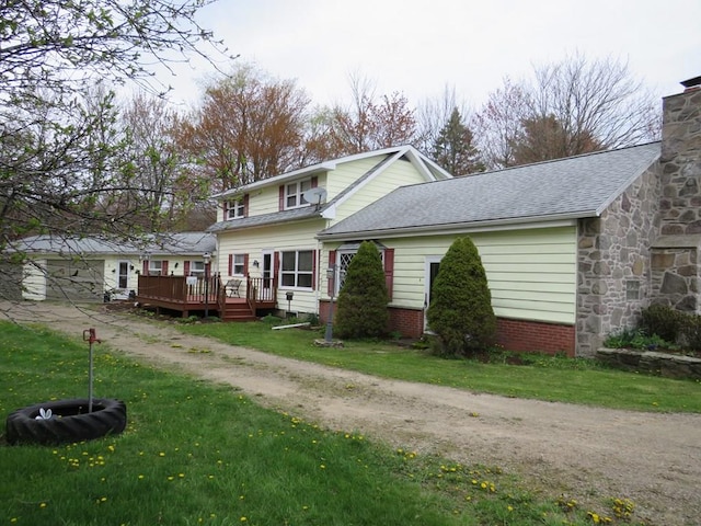 view of property featuring a wooden deck and a front lawn