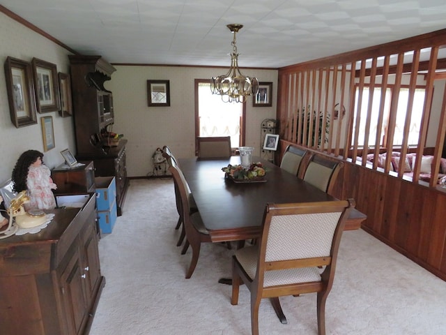 carpeted dining room with a notable chandelier and ornamental molding