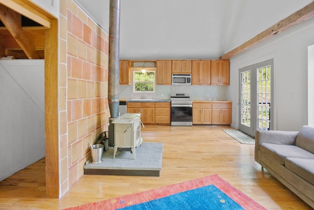 511 Steam Mill Rd, Wellsboro, PA 16901 - kitchen with stainless steel appliances, a wood stove, light wood finished floors, light countertops, and a sink