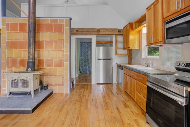 511 Steam Mill Rd, Wellsboro, PA 16901 - kitchen with appliances with stainless steel finishes, a sink, a wood stove, lofted ceiling, and light wood-style floors