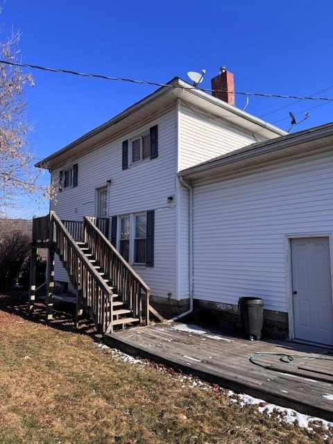 back of house featuring a wooden deck and a yard