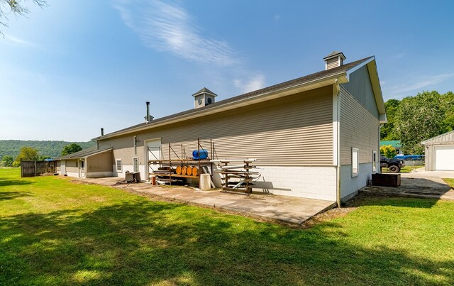 back of property featuring a patio area and a lawn