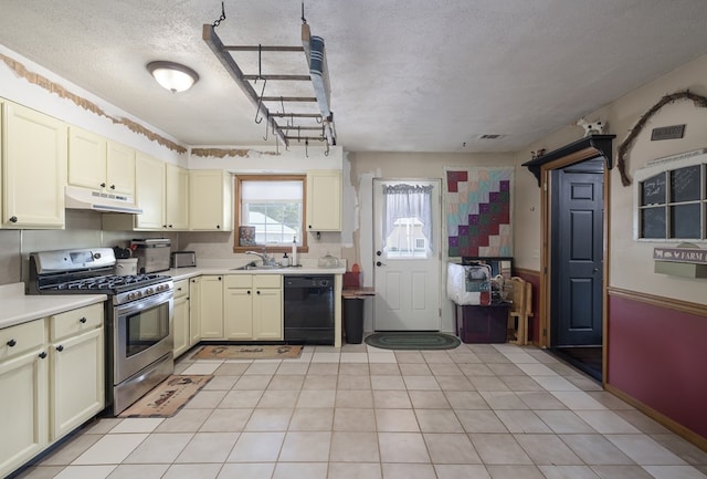 kitchen featuring stainless steel gas stove, black dishwasher, under cabinet range hood, cream cabinetry, and light countertops