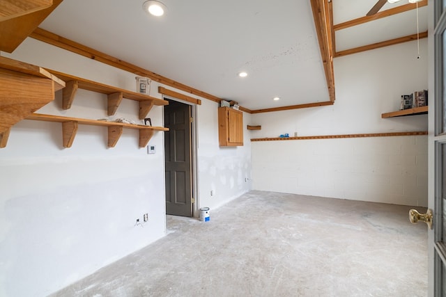 spare room with concrete floors, recessed lighting, and concrete block wall