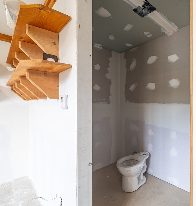 bathroom with toilet and concrete floors