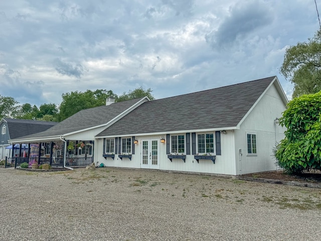 single story home featuring roof with shingles, a chimney, and french doors