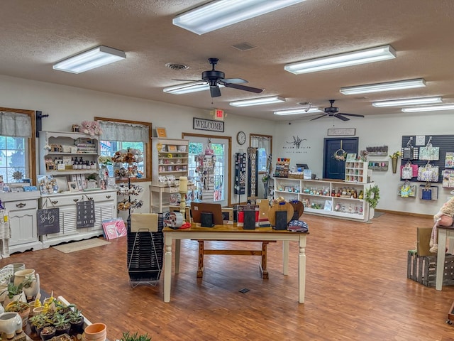 interior space with visible vents, a textured ceiling, and wood finished floors