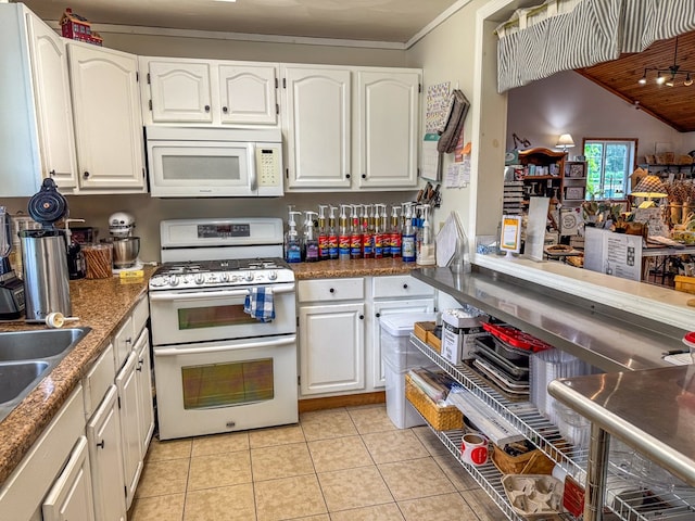 kitchen featuring range with two ovens, dark countertops, white cabinetry, and white microwave