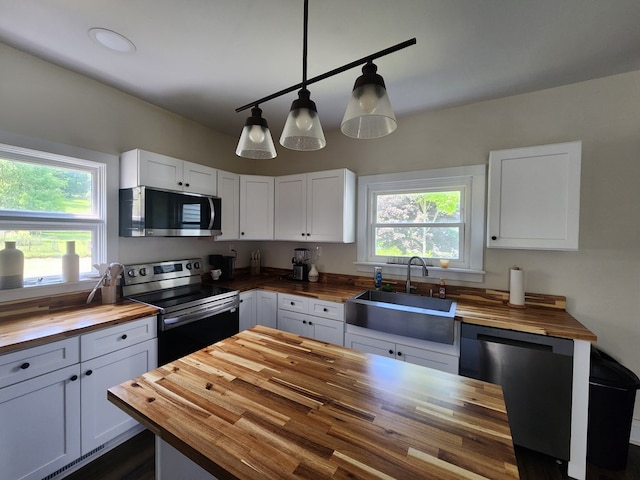 406 E Maple St, Coudersport, PA 16915 - kitchen with wood counters, appliances with stainless steel finishes, white cabinetry, and pendant lighting