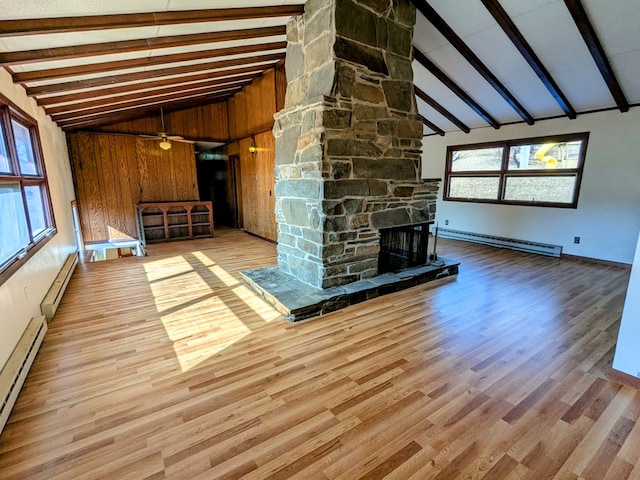 unfurnished living room with beamed ceiling, baseboard heating, and a fireplace