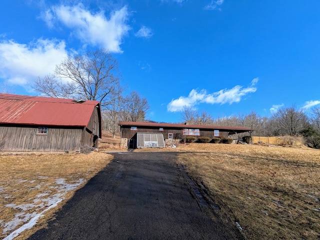 view of front of house with driveway and an outbuilding