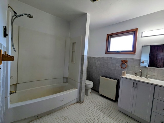 full bathroom featuring toilet, vanity, tile walls,  shower combination, and tile patterned floors