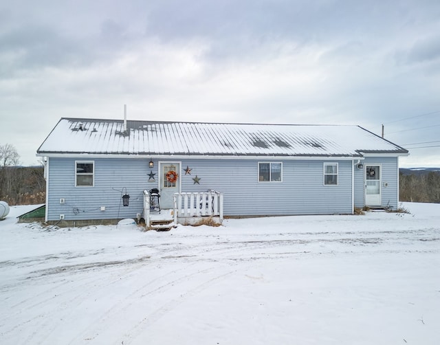 view of snow covered back of property