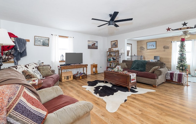 living room featuring light wood-type flooring, plenty of natural light, and ceiling fan