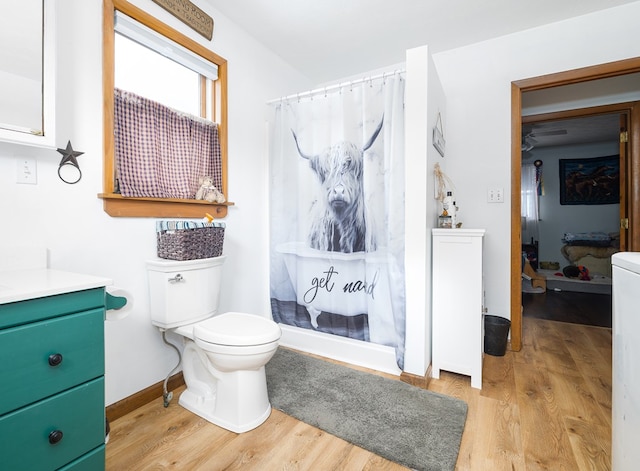 bathroom featuring a shower with curtain, toilet, vanity, and hardwood / wood-style flooring