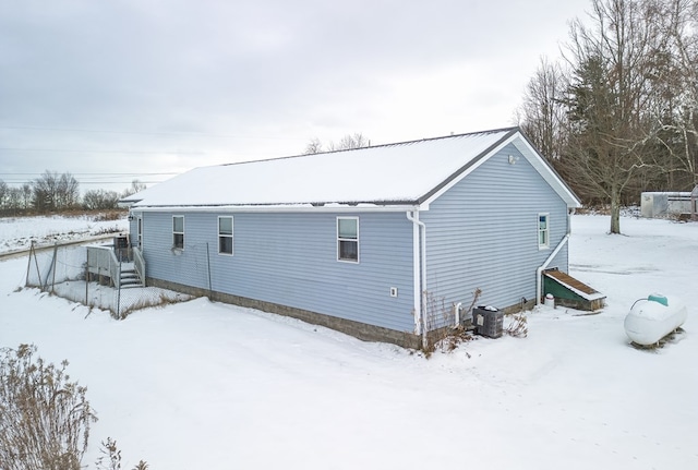 snow covered back of property with central AC unit