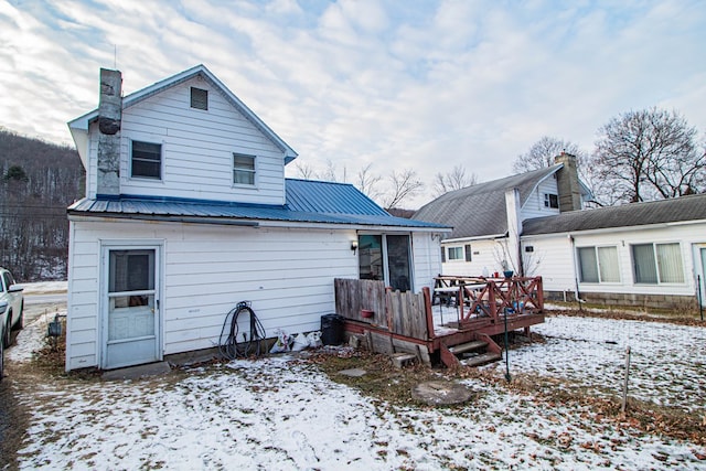 snow covered property with a wooden deck