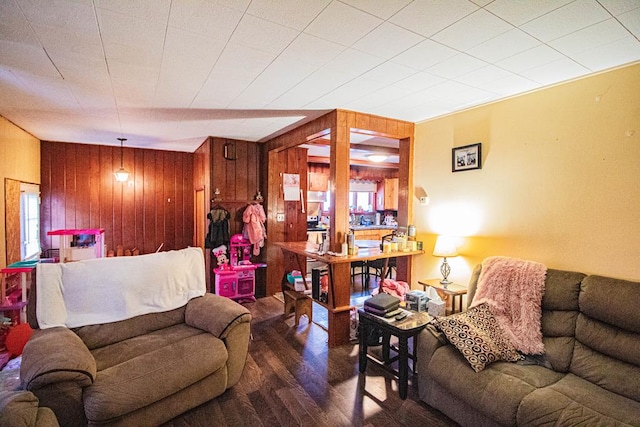 living room with a healthy amount of sunlight, hardwood / wood-style flooring, and wooden walls